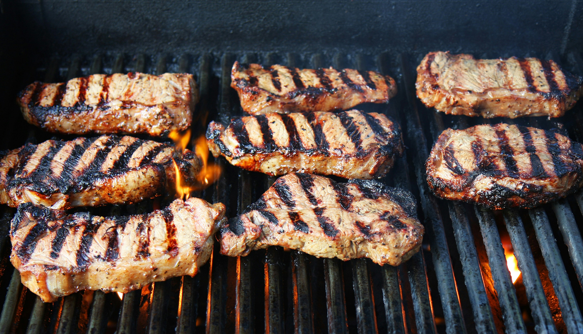 Fleisch wird auf einem Grillrost gegrillt