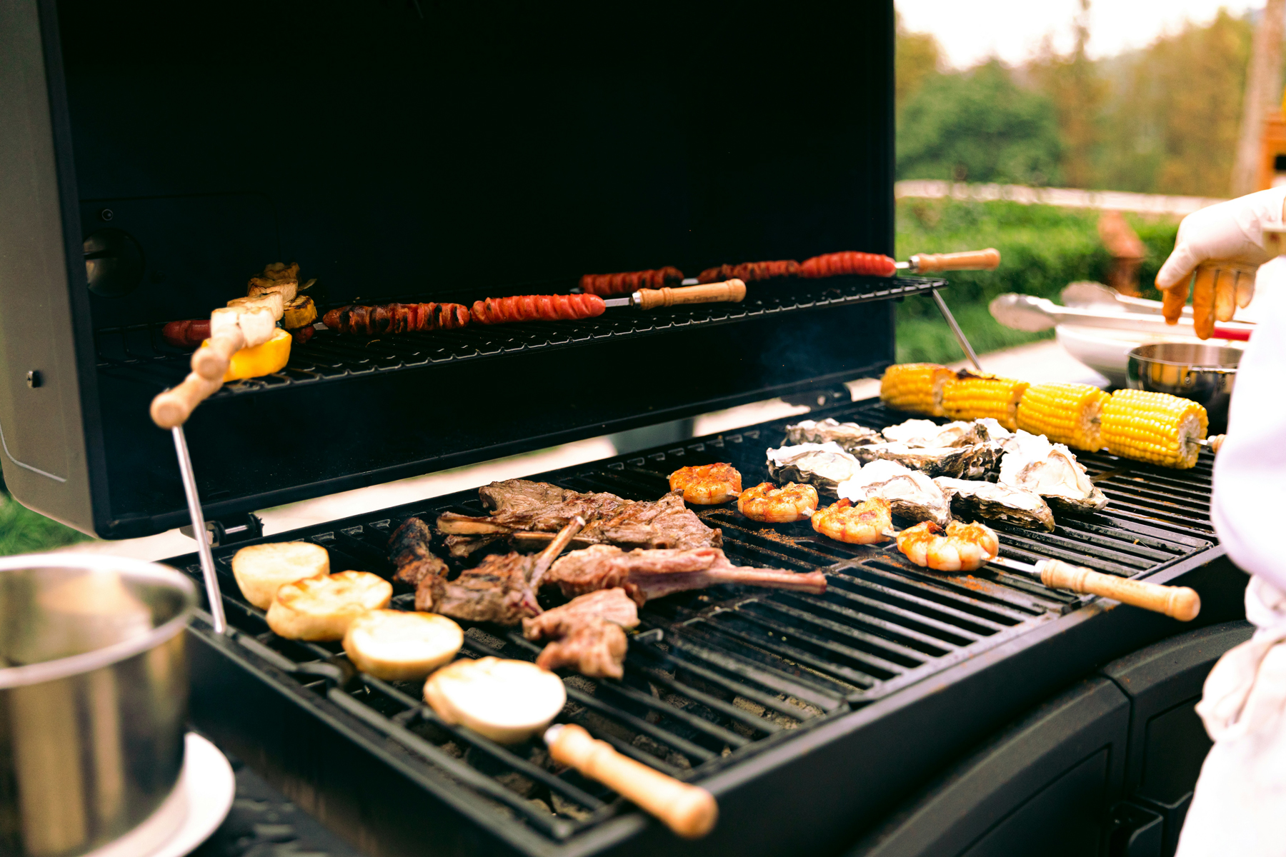Grillbürste reinigt einen Gussrost nach dem Grillen